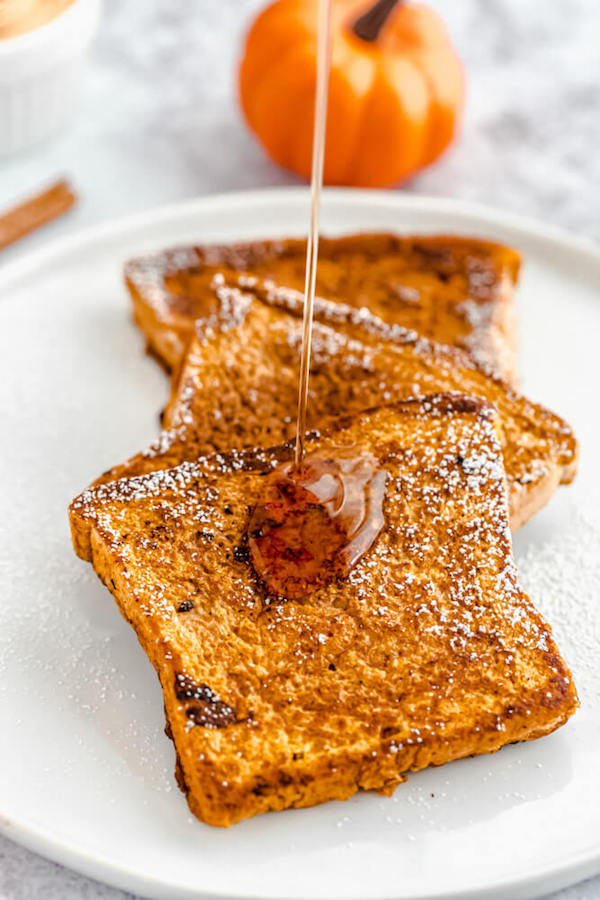 pouring maple syrup onto pumpkin French toast