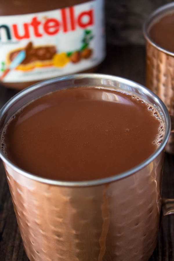 Nutella lovers gather around! This Nutella Hot Chocolate is thick, rich, creamy and decadent! Topped with Nutella Whipped Cream, melted Nutella, chopped hazelnuts and Ferrero Rochers — this is the ultimate drink for every Nutella fanatic!