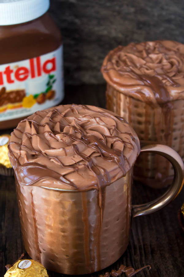 Nutella lovers gather around! This Nutella Hot Chocolate is thick, rich, creamy and decadent! Topped with Nutella Whipped Cream, melted Nutella, chopped hazelnuts and Ferrero Rochers — this is the ultimate drink for every Nutella fanatic!