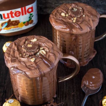 Nutella lovers gather around! This Nutella Hot Chocolate is thick, rich, creamy and decadent! Topped with Nutella Whipped Cream, melted Nutella, chopped hazelnuts and Ferrero Rochers — this is the ultimate drink for every Nutella fanatic!