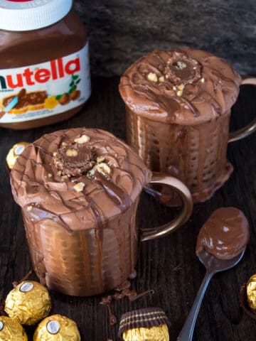 Nutella lovers gather around! This Nutella Hot Chocolate is thick, rich, creamy and decadent! Topped with Nutella Whipped Cream, melted Nutella, chopped hazelnuts and Ferrero Rochers — this is the ultimate drink for every Nutella fanatic!