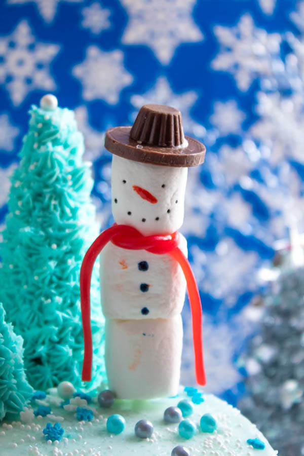 This Winter Wonderland Cake has all the magic and beauty of winter inside a cake! With a wintery white and blue theme, marshmallow snowmen, sugar cone Christmas trees and a powdered sugar snow drip, this is the perfect dessert for your Winter Wonderland themed party!