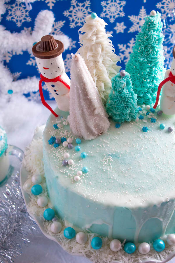 This Winter Wonderland Cake has all the magic and beauty of winter inside a cake! With a wintery white and blue theme, marshmallow snowmen, sugar cone Christmas trees and a powdered sugar snow drip, this is the perfect dessert for your Winter Wonderland themed party!