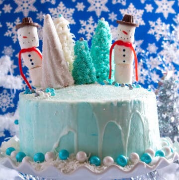 This Winter Wonderland Cake has all the magic and beauty of winter inside a cake! With a wintery white and blue theme, marshmallow snowmen, sugar cone Christmas trees and a powdered sugar snow drip, this is the perfect dessert for your Winter Wonderland themed party!