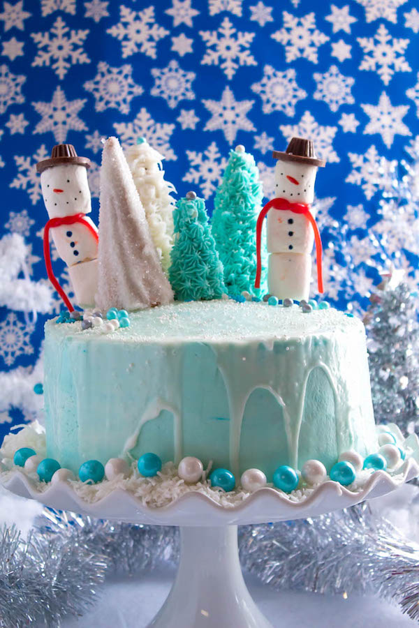 This Winter Wonderland Cake has all the magic and beauty of winter inside a cake! With a wintery white and blue theme, marshmallow snowmen, sugar cone Christmas trees and a powdered sugar snow drip, this is the perfect dessert for your Winter Wonderland themed party!