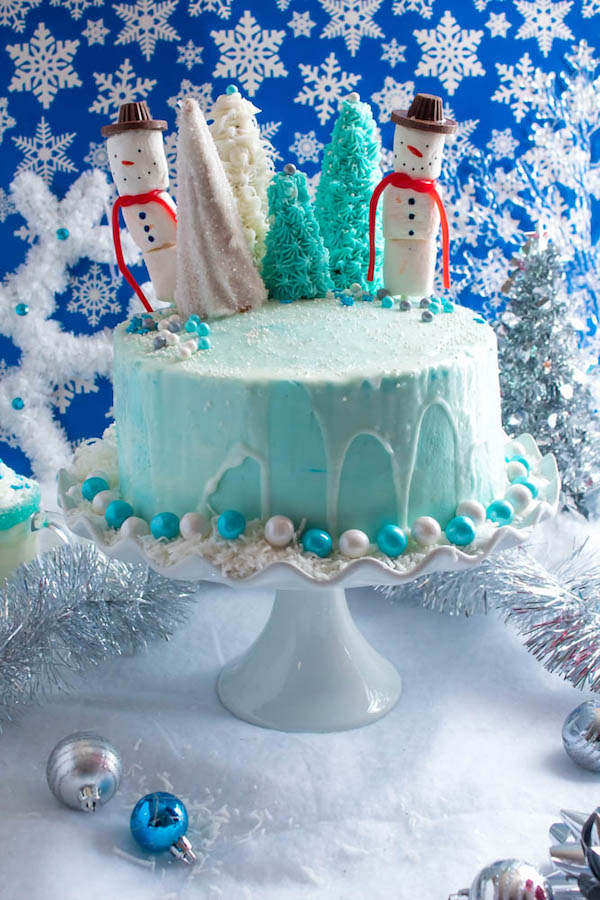 This Winter Wonderland Cake has all the magic and beauty of winter inside a cake! With a wintery white and blue theme, marshmallow snowmen, sugar cone Christmas trees and a powdered sugar snow drip, this is the perfect dessert for your Winter Wonderland themed party!