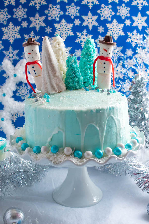 This Winter Wonderland Cake has all the magic and beauty of winter inside a cake! With a wintery white and blue theme, marshmallow snowmen, sugar cone Christmas trees and a powdered sugar snow drip, this is the perfect dessert for your Winter Wonderland themed party!