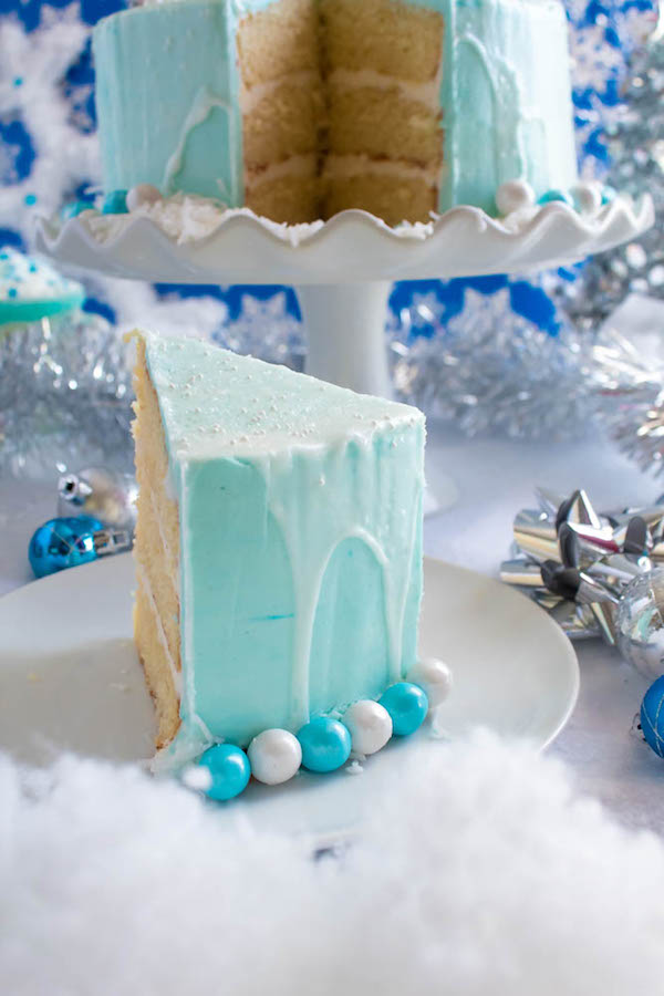 This Winter Wonderland Cake has all the magic and beauty of winter inside a cake! With a wintery white and blue theme, marshmallow snowmen, sugar cone Christmas trees and a powdered sugar snow drip, this is the perfect dessert for your Winter Wonderland themed party!