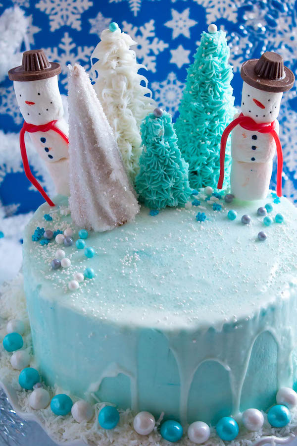 This Winter Wonderland Cake has all the magic and beauty of winter inside a cake! With a wintery white and blue theme, marshmallow snowmen, sugar cone Christmas trees and a powdered sugar snow drip, this is the perfect dessert for your Winter Wonderland themed party!