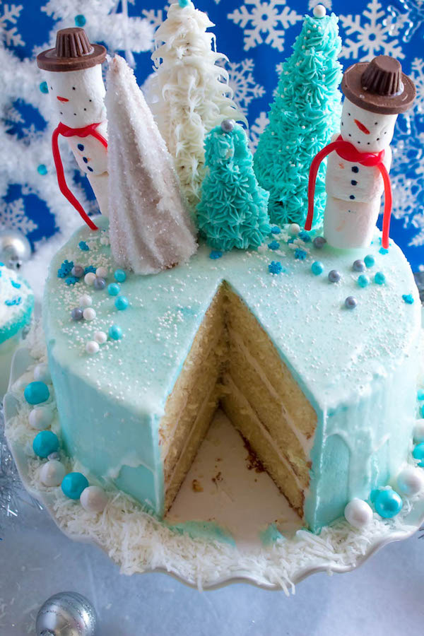 This Winter Wonderland Cake has all the magic and beauty of winter inside a cake! With a wintery white and blue theme, marshmallow snowmen, sugar cone Christmas trees and a powdered sugar snow drip, this is the perfect dessert for your Winter Wonderland themed party!