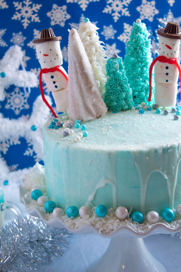 This Winter Wonderland Cake has all the magic and beauty of winter inside a cake! With a wintery white and blue theme, marshmallow snowmen, sugar cone Christmas trees and a powdered sugar snow drip, this is the perfect dessert for your Winter Wonderland themed party!