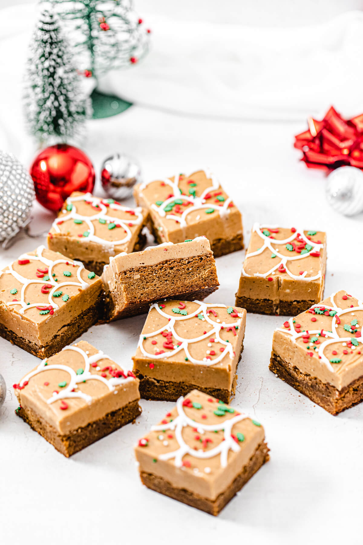 pile of gingerbread blondies with ornaments and Christmas trees in the background