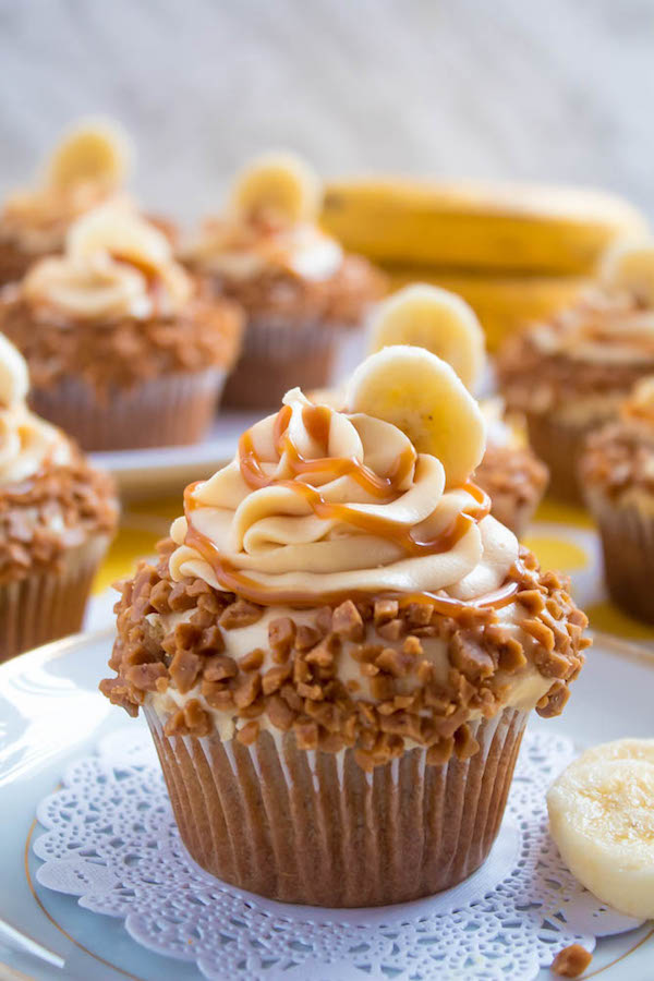These Banana Caramel Cupcakes are moist, fluffy, tender and have the most perfect banana flavour! Filled with homemade caramel sauce, rolled in toffee bits and topped with Caramel Cream Cheese Frosting — these cupcakes will have your taste buds going crazy!