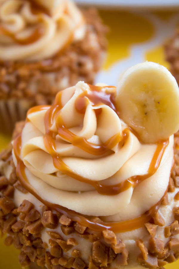 These Banana Caramel Cupcakes are moist, fluffy, tender and have the most perfect banana flavour! Filled with homemade caramel sauce, rolled in toffee bits and topped with Caramel Cream Cheese Frosting — these cupcakes will have your taste buds going crazy!