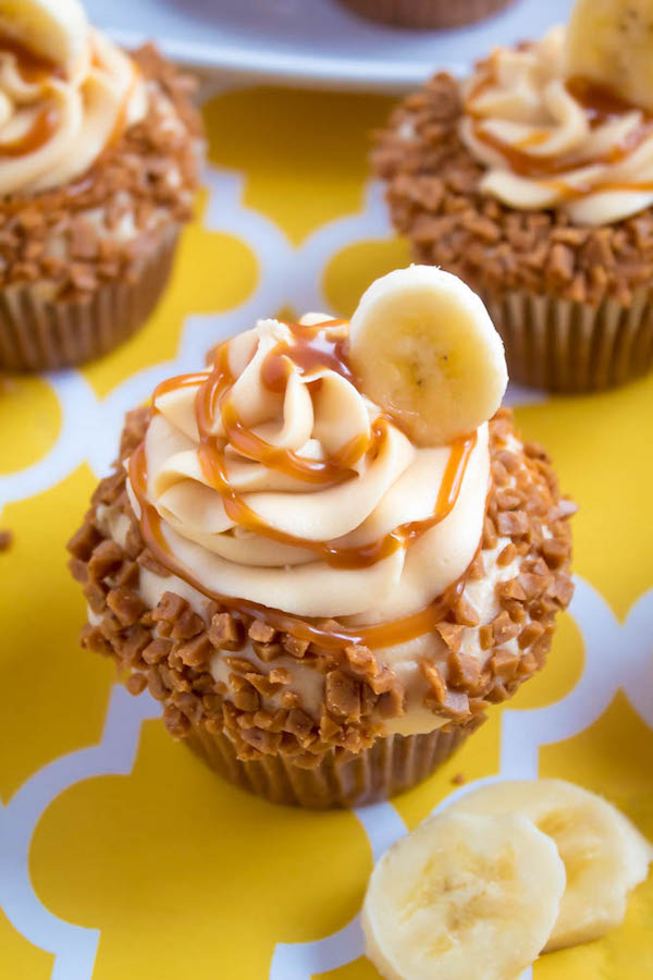 These Banana Caramel Cupcakes are moist, fluffy, tender and have the most perfect banana flavour! Filled with homemade caramel sauce, rolled in toffee bits and topped with Caramel Cream Cheese Frosting — these cupcakes will have your taste buds going crazy!