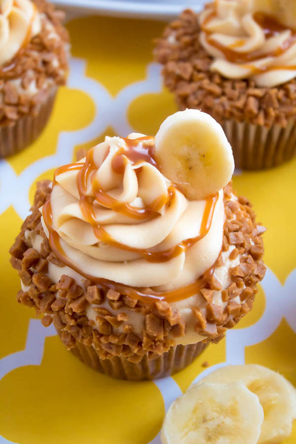 These Banana Caramel Cupcakes are moist, fluffy, tender and have the most perfect banana flavour! Filled with homemade caramel sauce, rolled in toffee bits and topped with Caramel Cream Cheese Frosting — these cupcakes will have your taste buds going crazy!