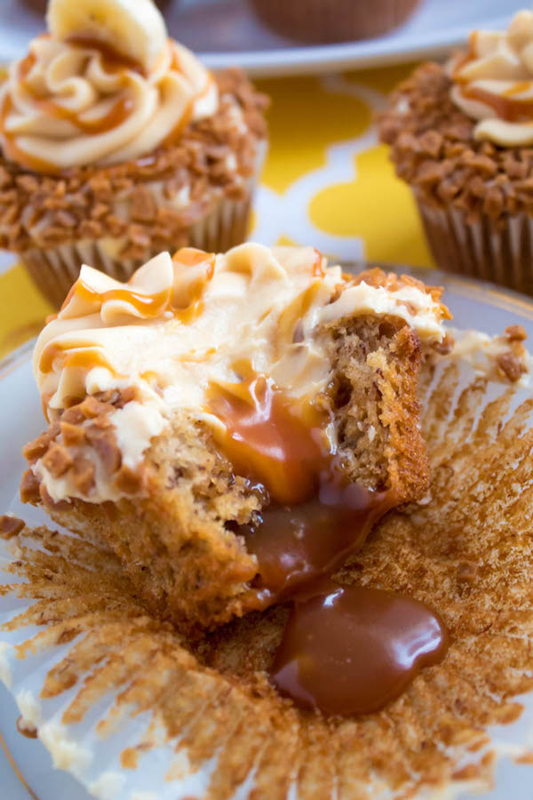 These Banana Caramel Cupcakes are moist, fluffy, tender and have the most perfect banana flavour! Filled with homemade caramel sauce, rolled in toffee bits and topped with Caramel Cream Cheese Frosting — these cupcakes will have your taste buds going crazy!