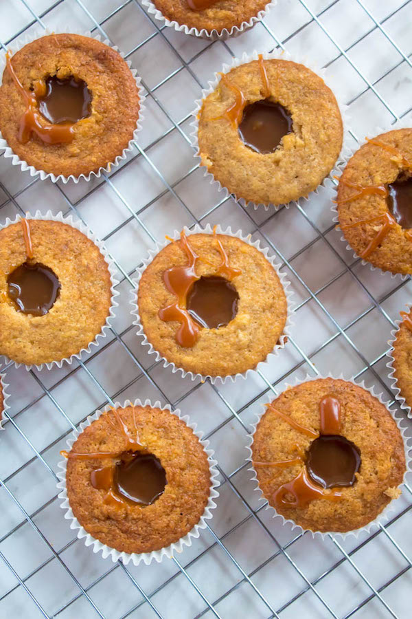 These Banana Caramel Cupcakes are moist, fluffy, tender and have the most perfect banana flavour! Filled with homemade caramel sauce, rolled in toffee bits and topped with Caramel Cream Cheese Frosting — these cupcakes will have your taste buds going crazy!