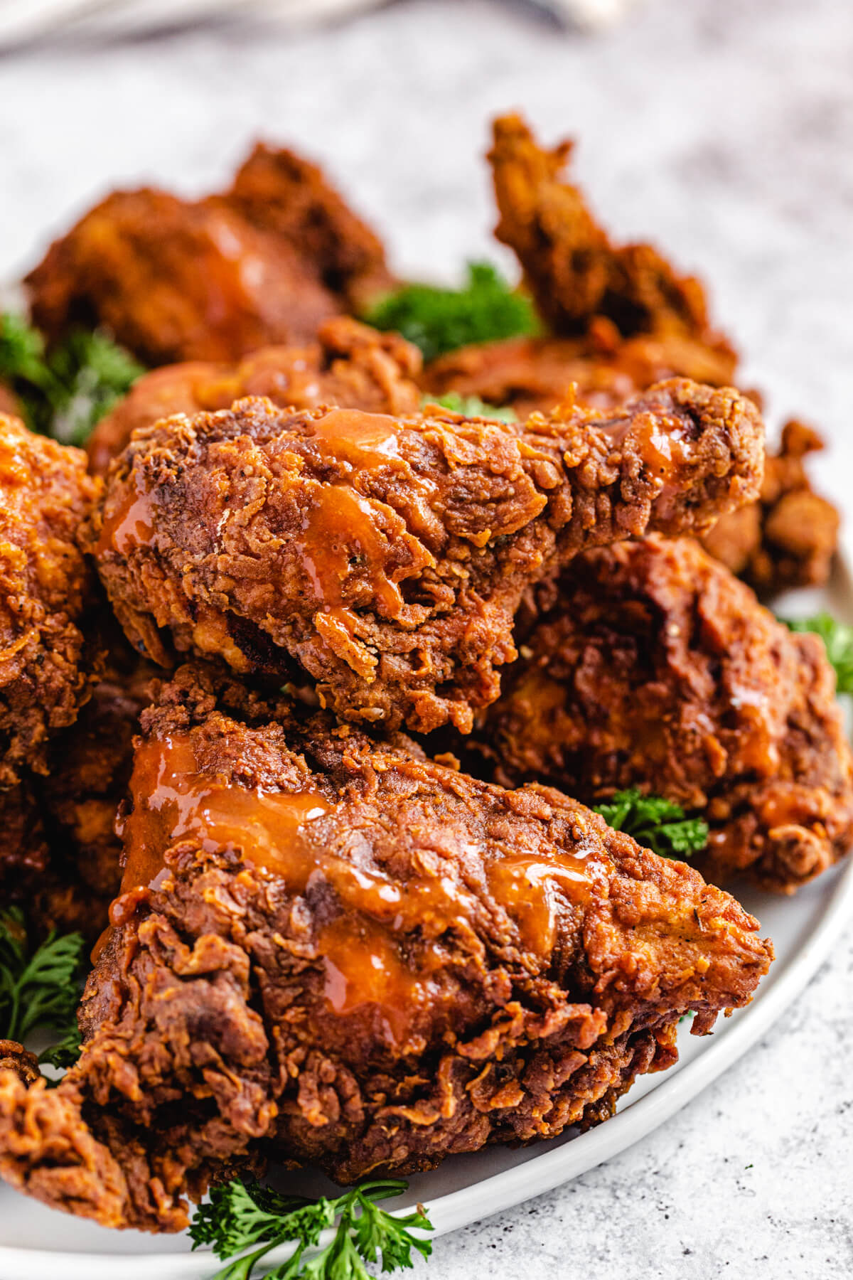 chicken topped with hot sauce on a white round platter