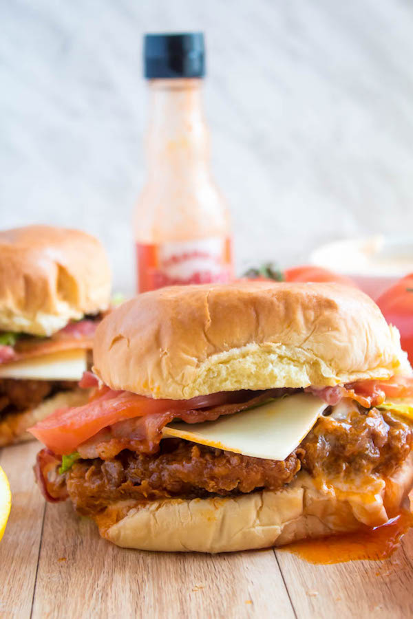 These Spicy Fried Chicken Sandwiches are crispy, juicy and seasoned to perfection. Sandwiched between toasted brioche buns, fresh lettuce, tomatoes, mozzarella, crispy bacon and a flavourful spicy aioli — these fried chicken sandwiches are comfort food at its best!