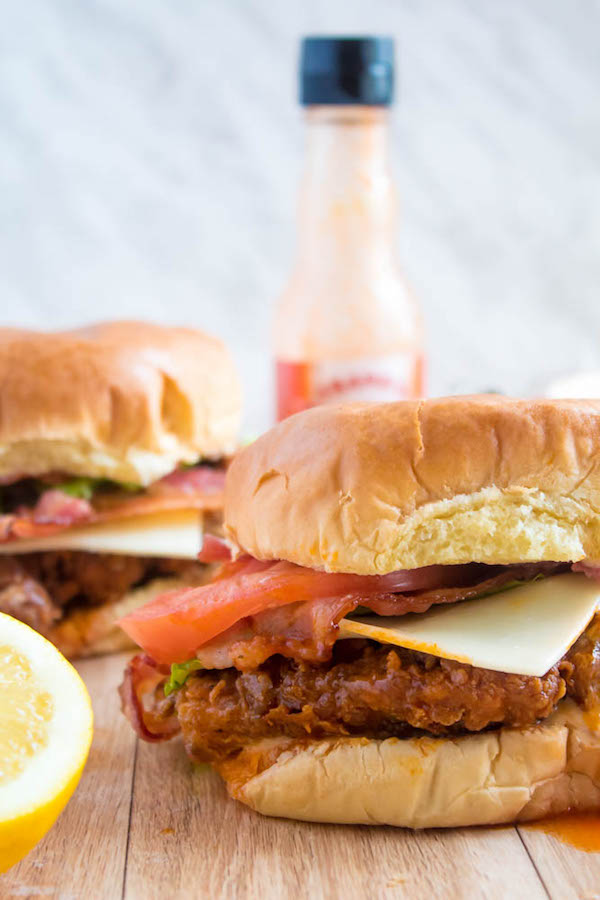 These Spicy Fried Chicken Sandwiches are crispy, juicy and seasoned to perfection. Sandwiched between toasted brioche buns, fresh lettuce, tomatoes, mozzarella, crispy bacon and a flavourful spicy aioli — these fried chicken sandwiches are comfort food at its best!