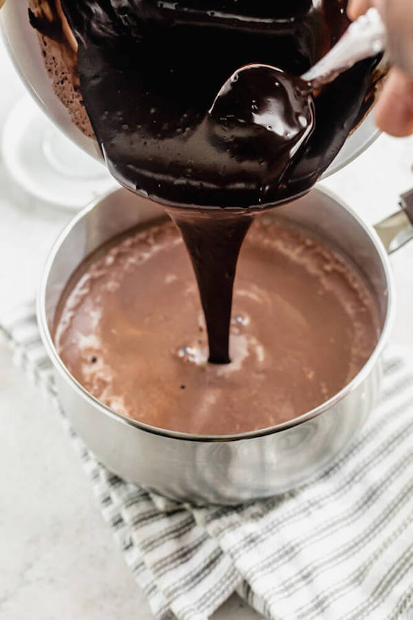 pouring ganache into a saucepan of chocolate milk