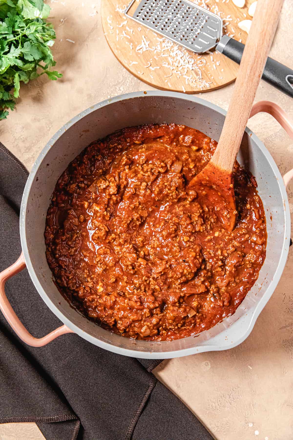 pot of sauce with grater and parmesan around it