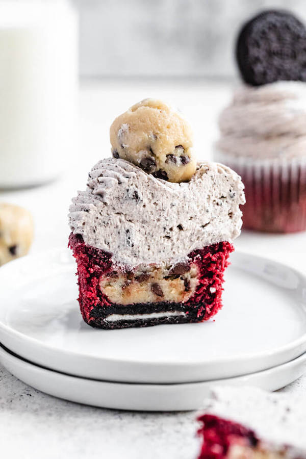 halved cookie dough stuffed cupcake on a stack of small white plates