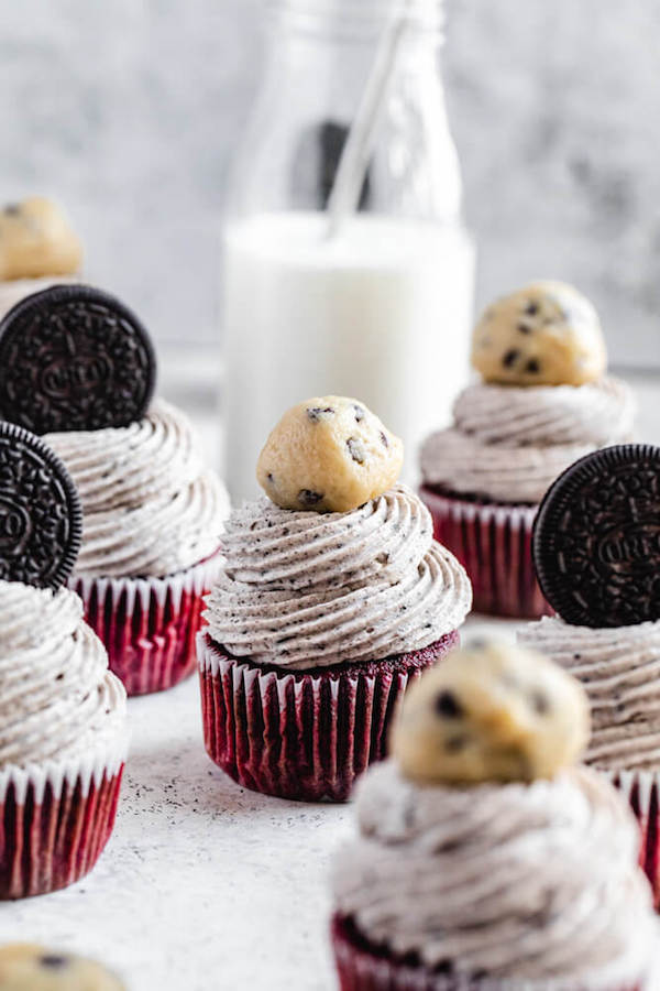 red velvet oreo and cookie dough cupcakes with milk bottle in the background