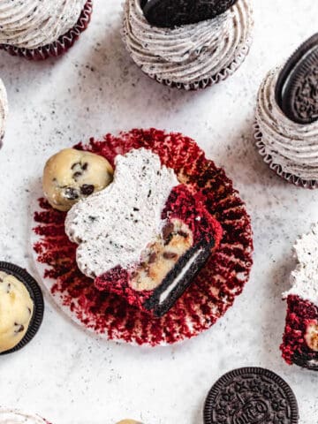 red velvet cupcake cut in half showing Oreo cookie and cookie dough ball inside