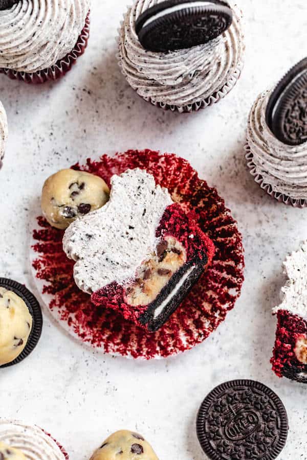 red velvet cupcake cut in half showing Oreo cookie and cookie dough ball inside