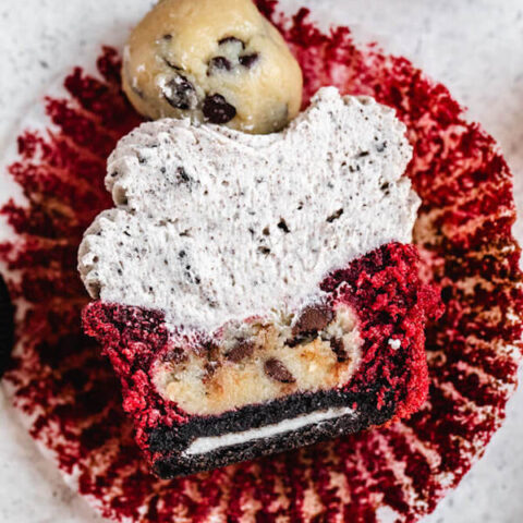 halved red velvet cupcake stuffed with Oreo and cookie dough