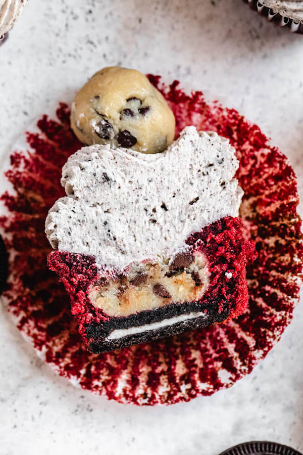 halved red velvet cupcake stuffed with Oreo and cookie dough