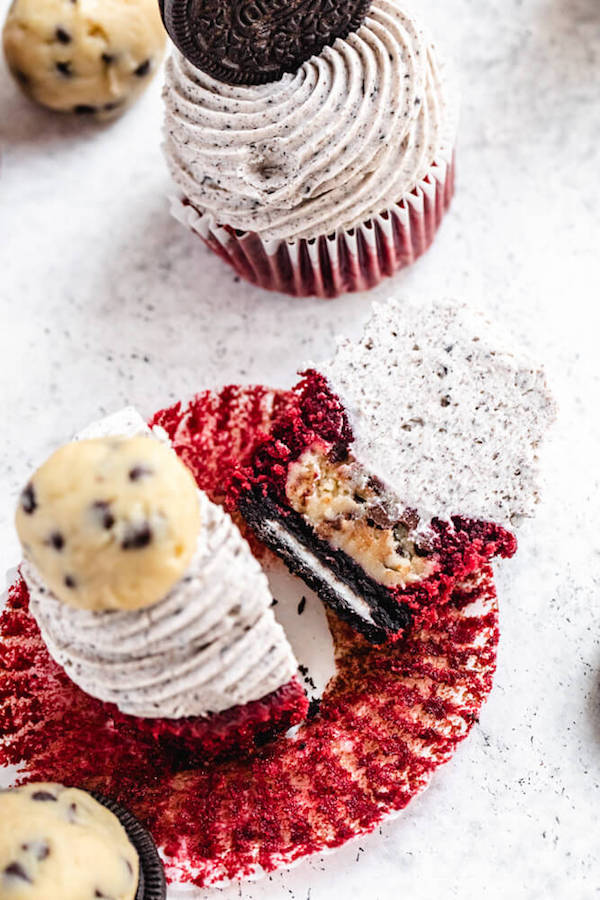 Oreo cookie and cookie dough ball inside of a red velvet cupcake