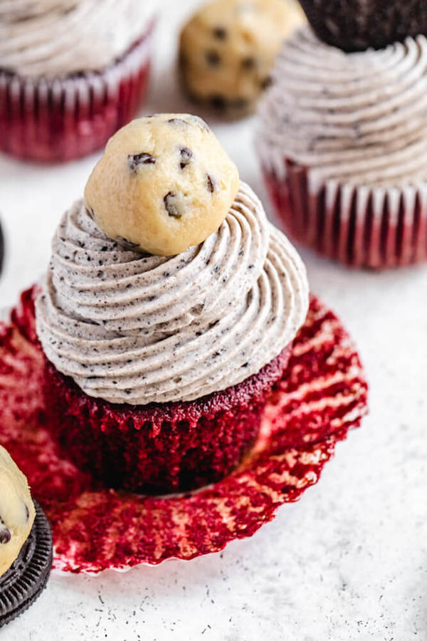close up of red velvet flavoured cupcake topped with Oreo frosting and cookie dough