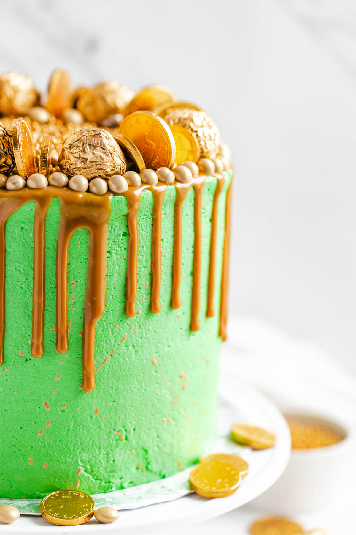 close up view of green and gold cake on a cake stand