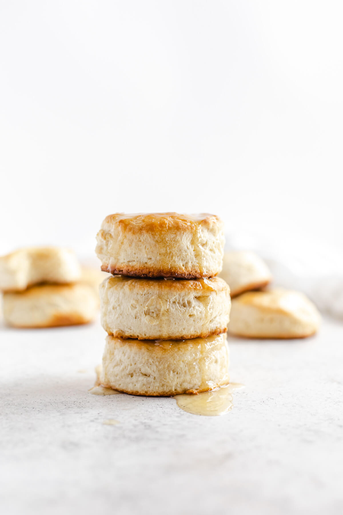 three biscuits stacked on top of each other with honey butter dripping down