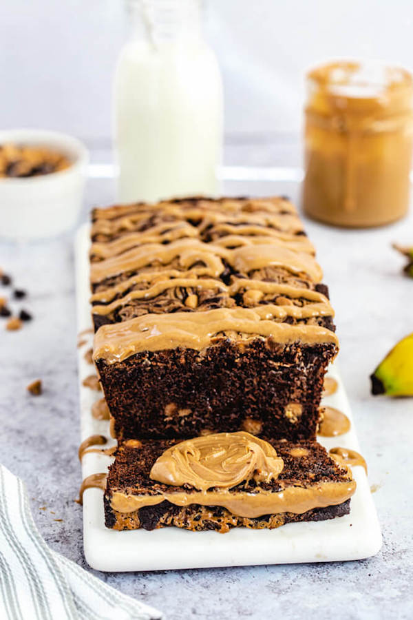 sliced chocolate banana bread loaf with a dollop of peanut butter in the middle of a slice