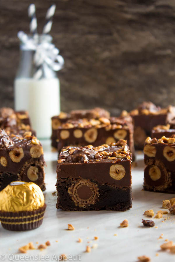 These Ferrero Rocher Fudge Brownies are the ultimate dessert bars! A Ferrero Rocher stuffed fudge brownie, topped with a creamy Nutella Fudge filled and topped with Ferrero Rochers and roasted hazelnuts. Take these bars to another level with a drizzle of silky Nutella Ganache and you’ve got the greatest brownie ever!  