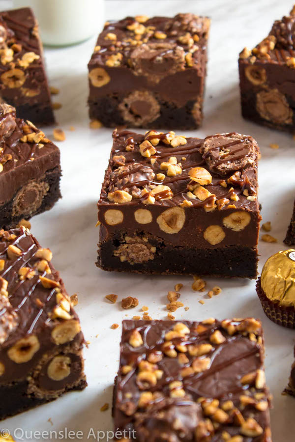 These Ferrero Rocher Fudge Brownies are the ultimate dessert bars! A Ferrero Rocher stuffed fudge brownie, topped with a creamy Nutella Fudge filled and topped with Ferrero Rochers and roasted hazelnuts. Take these bars to another level with a drizzle of silky Nutella Ganache and you’ve got the greatest brownie ever!  