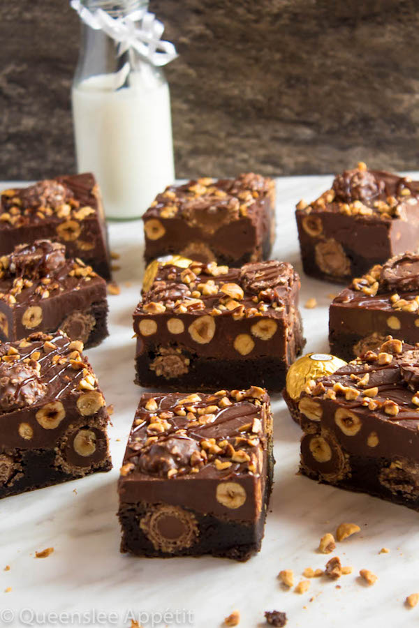 These Ferrero Rocher Fudge Brownies are the ultimate dessert bars! A Ferrero Rocher stuffed fudge brownie, topped with a creamy Nutella Fudge filled and topped with Ferrero Rochers and roasted hazelnuts. Take these bars to another level with a drizzle of silky Nutella Ganache and you’ve got the greatest brownie ever!  