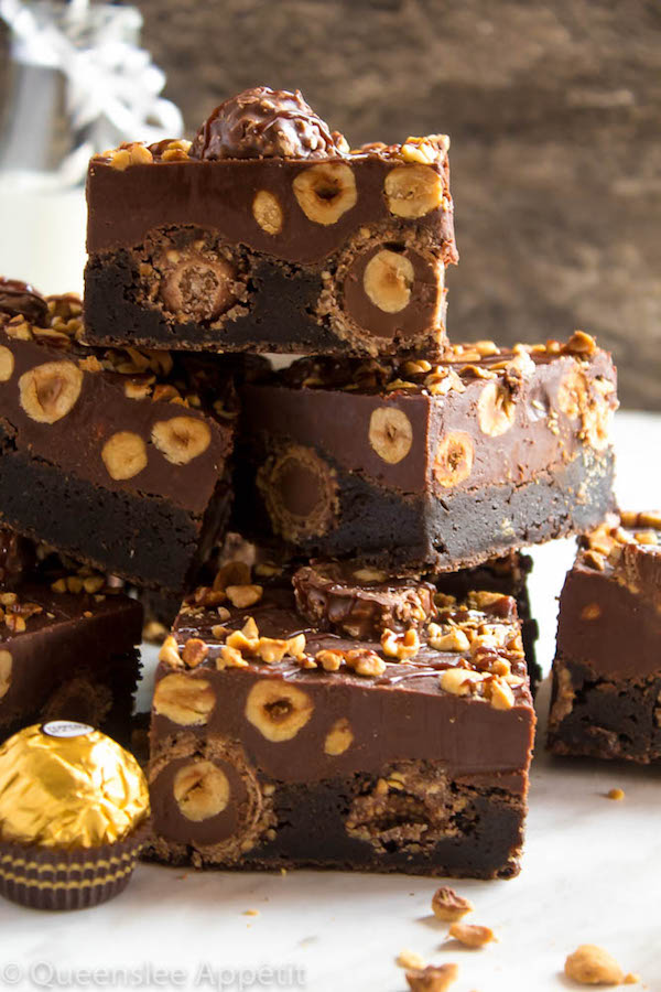 These Ferrero Rocher Fudge Brownies are the ultimate dessert bars! A Ferrero Rocher stuffed fudge brownie, topped with a creamy Nutella Fudge filled and topped with Ferrero Rochers and roasted hazelnuts. Take these bars to another level with a drizzle of silky Nutella Ganache and you’ve got the greatest brownie ever!  