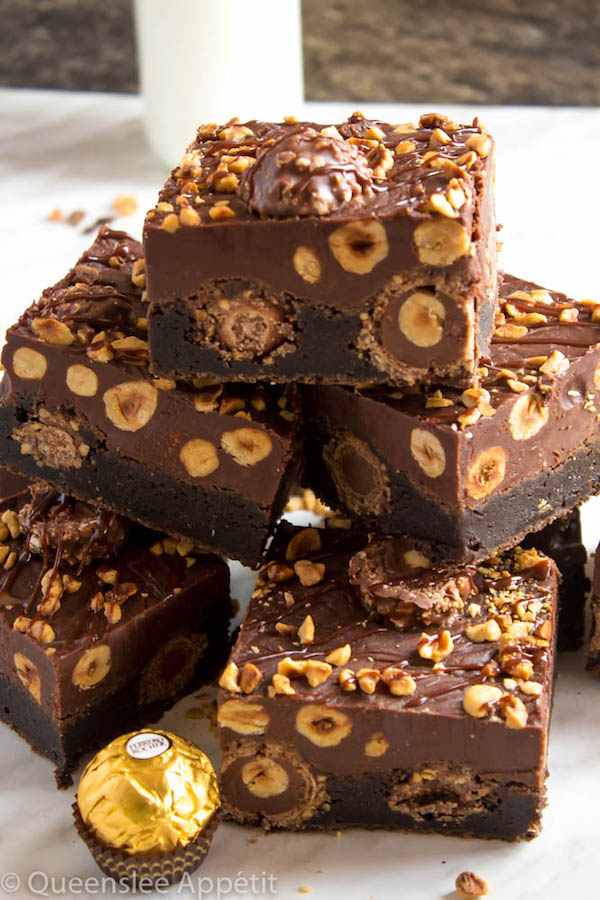 These Ferrero Rocher Fudge Brownies are the ultimate dessert bars! A Ferrero Rocher stuffed fudge brownie, topped with a creamy Nutella Fudge filled and topped with Ferrero Rochers and roasted hazelnuts. Take these bars to another level with a drizzle of silky Nutella Ganache and you’ve got the greatest brownie ever!  