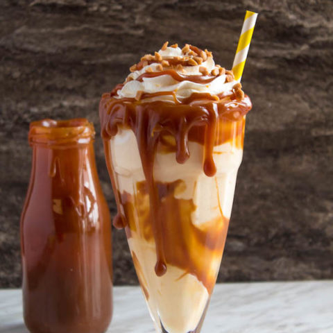 This Salted Caramel Milkshake is made with creamy vanilla ice cream and homemade salted caramel sauce. Topped with fluffy whipped cream, extra salted caramel sauce and toffee bits — this is the perfect chilly drink to indulge in this summer! 