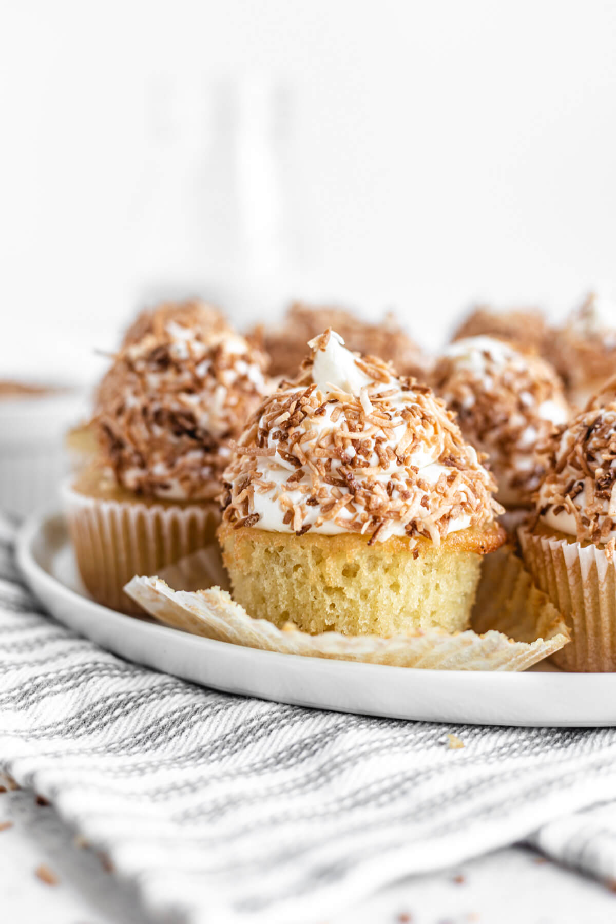 close up of cupcakes on a white plate with unwrapped cupcake in the front