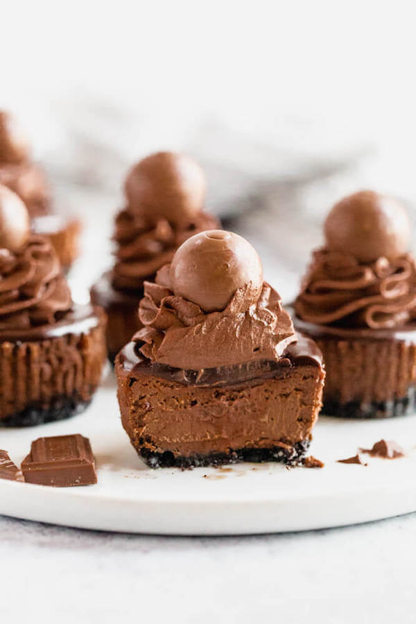 mini chocolate cheesecakes made with an Oreo crust and topped with dark chocolate ganache, chocolate whipped cream and chocolate truffles.