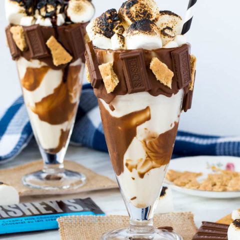 Give me S’mores Milkshake — milk chocolate and graham cracker decorated glass filled with a toasted marshmallow milkshake and topped with charred marshmallows! 