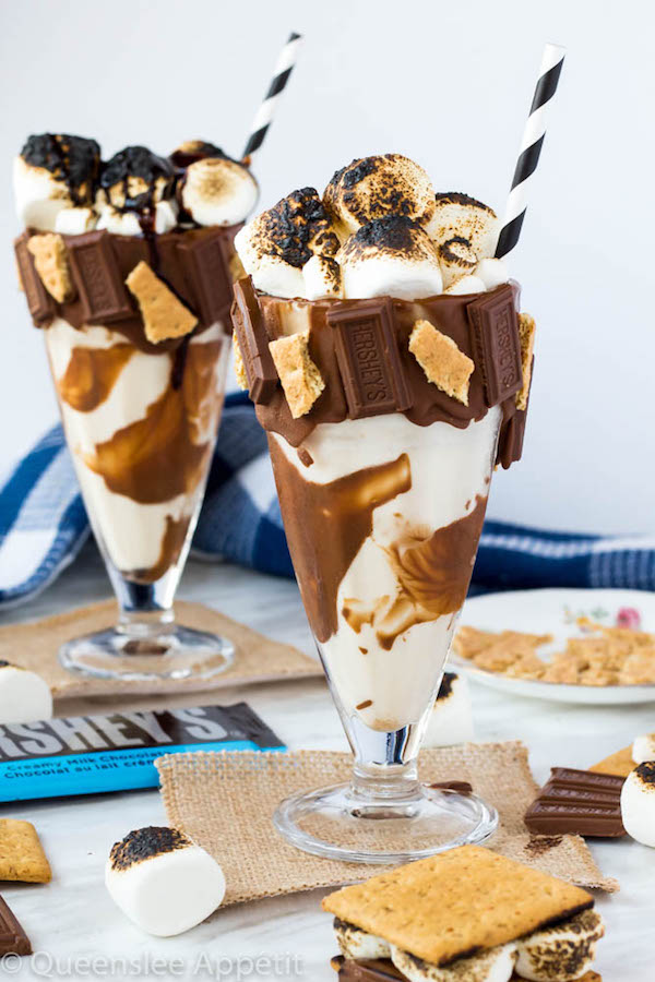 Give me S’mores Milkshake — milk chocolate and graham cracker decorated glass filled with a toasted marshmallow milkshake and topped with charred marshmallows! 