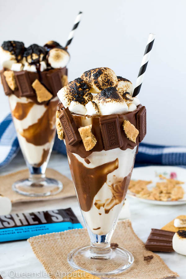 Give me S’mores Milkshake — milk chocolate and graham cracker decorated glass filled with a toasted marshmallow milkshake and topped with charred marshmallows! 