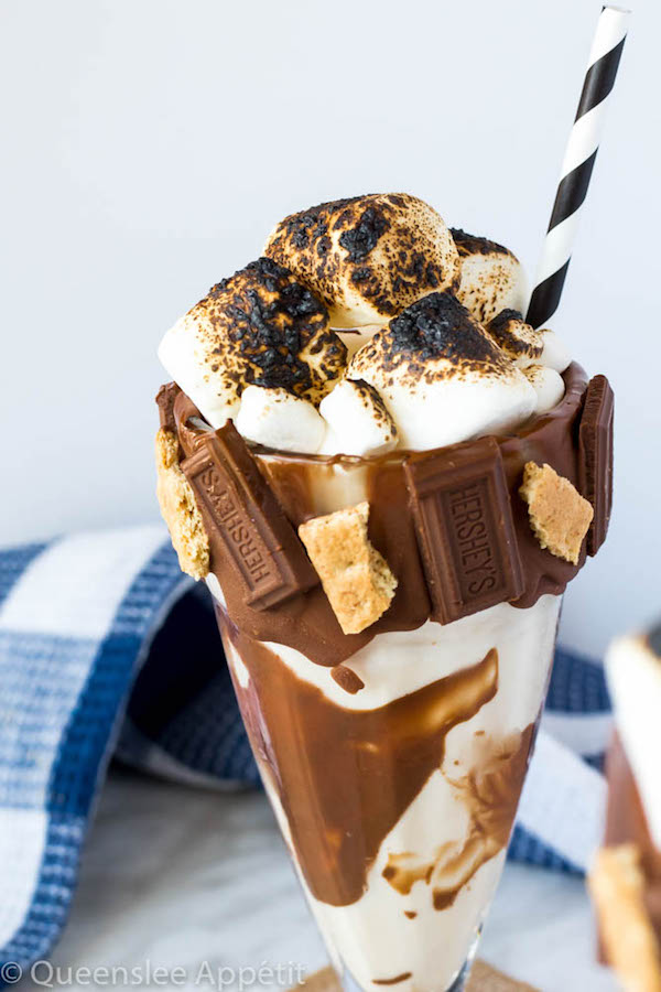 Give me S’mores Milkshake — milk chocolate and graham cracker decorated glass filled with a toasted marshmallow milkshake and topped with charred marshmallows! 